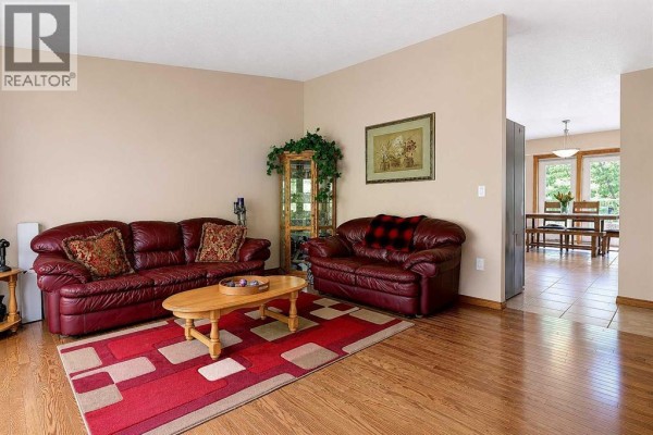 Living room with fireplace, leather recliners, sofa, and sliding glass doors to the yard. - 9, 712051 Range Road 54, Rural Grande Prairie No  1, County Of