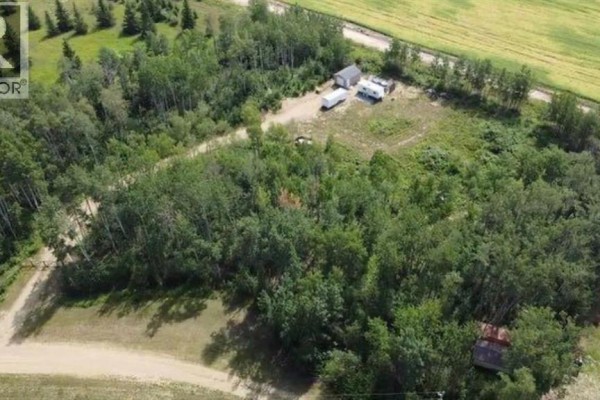 Aerial view of a wooded property with a gravel road and structures. - 9, 842052 Range Road 241, Rural Northern Lights, County Of