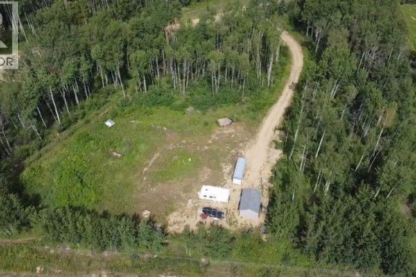 Aerial view of a cleared area with several structures and a trailer. - 9, 842052 Range Road 241, Rural Northern Lights, County Of