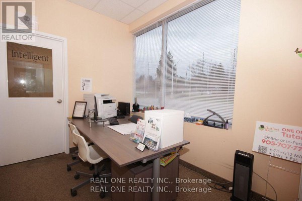 Desk with computer, printer, and window view in a commercial office space - #9 - 1455 Sixteenth Avenue, Richmond Hill