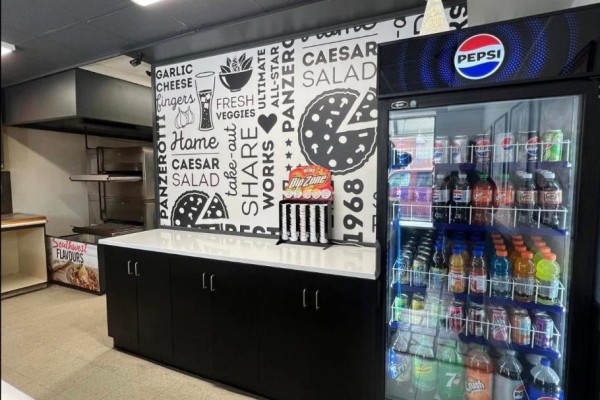 Black cabinets below a white counter with a Pepsi branded refrigerator stocked with beverages. - 9 - 181 St Andrew Street E, Centre Wellington