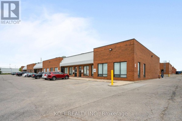 Exterior view of a brick commercial building with parking lot and multiple units. - 9 - 190 Britannia Road E, Mississauga