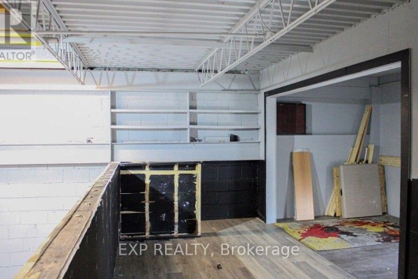 Interior space with white shelves, dark paneling, and a doorway leading to another room. - 9 - 30 Canvarco Road, Toronto