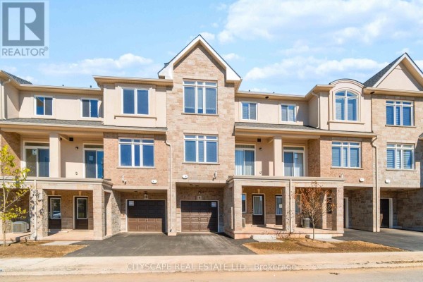 Front view of multiple brick and stone townhouses with garages and covered porches. - 9 - 40 Zinfandel Drive, Hamilton