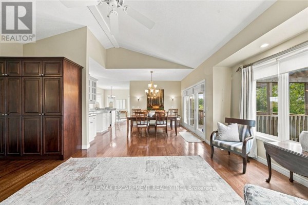 Open-concept living and dining area with vaulted ceiling, dark wood cabinets, and large windows. - 9 - 500 Lakeview Drive, Woodstock