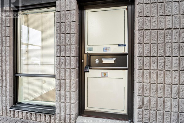 Close-up of commercial unit 9 door with a window and a lock. Textured brick exterior wall. - 9 - 85 Ferrier Street, Markham