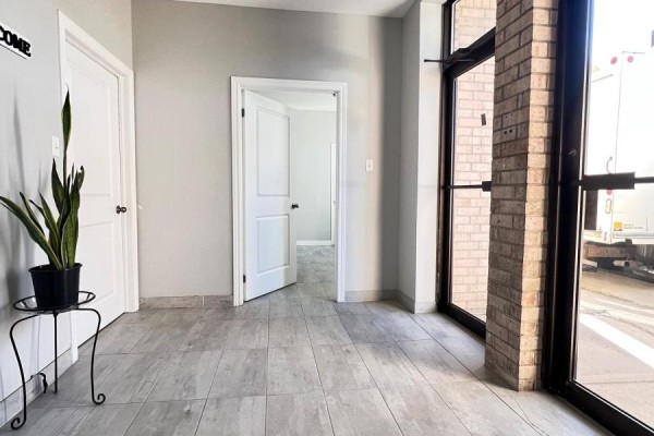 Entrance area with glass doors, brick columns, and a doorway leading to another room. - 9 & 10 - 6731 Columbus Road, Mississauga