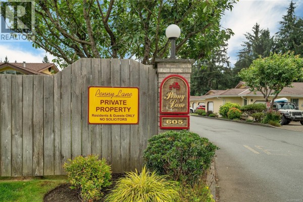 Wooden entrance gate with a 'Penny Lane Private Property' sign and brick pillar with address. - 9 605 Rockland Rd, Campbell River