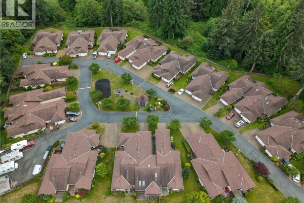 Overhead view of cul-de-sac streets winding through a townhouse complex with many red-tiled roofs. - 9 605 Rockland Rd, Campbell River
