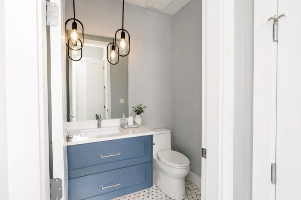 Powder room with a blue vanity, white countertop, modern faucet, and industrial-style pendant lights. - 9 7138 Marble Hill Road, Eastern Hillsides, Chilliwack