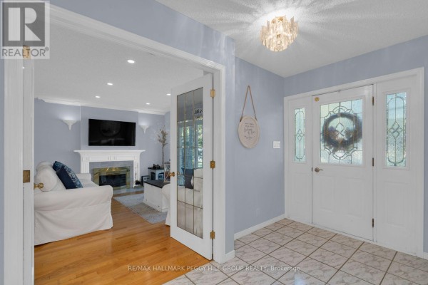 Interior foyer with double doors, light blue walls, tiled floor, and an opening to the living room. - 9 Cabell Road, Tiny