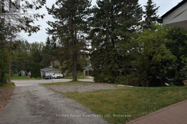 Living room with large windows, seating area, and mirror on the wall. - 9 Cedar Street, Cramahe