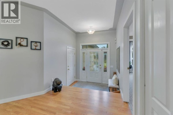 Entrance foyer with light wood floors, grey walls, and a glass-paneled front door. - 9 Creek Road, Rural Ponoka County