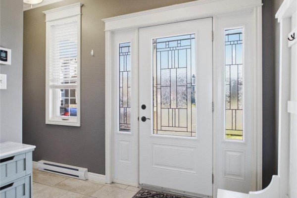 Interior view of a white front door with glass panels and decorative leaded glass inserts. - 9 Crestview Place, St  John S