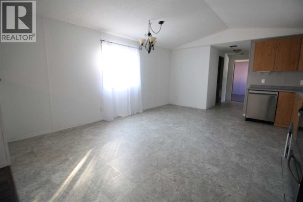 Living room with grey sectional sofa, wooden coffee table, and large rug. - 9 Deerridge Drive, High Level