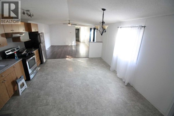 Kitchen and dining area with wood cabinets, stainless steel appliances, and dining table. - 9 Deerridge Drive, High Level