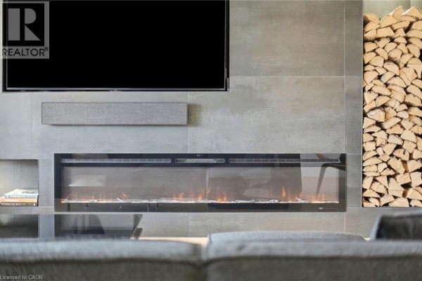 Close-up of modern linear fireplace and stacked wood on a tiled wall. - 9 Donlea Drive, Hamilton