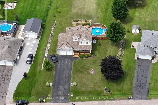 Aerial view of the property with a house, circular pool, garages, and surrounding greenery. - 9 Heron Drive, Laurentian Valley