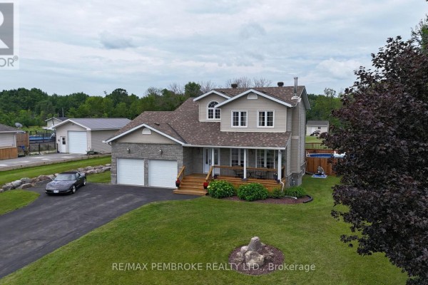 Three-quarter front view of the residential house with a driveway, garage, and mature trees. - 9 Heron Drive, Laurentian Valley