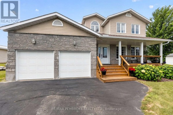 Close-up of the house entrance featuring a covered porch, wooden steps, and double garage doors. - 9 Heron Drive, Laurentian Valley