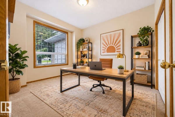 Home office with a desk, chair, shelves, and a large window overlooking greenery. - 9 Hillcrest Co, Spruce Grove