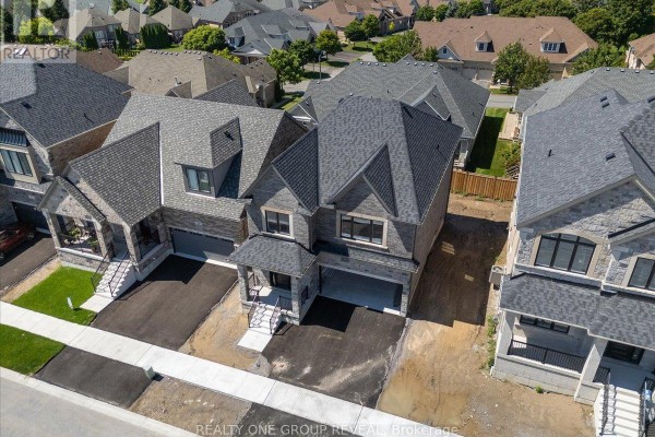 Aerial view of two suburban homes with dark grey roofs and stone and brick facades. - 9 Holland Street, Port Hope
