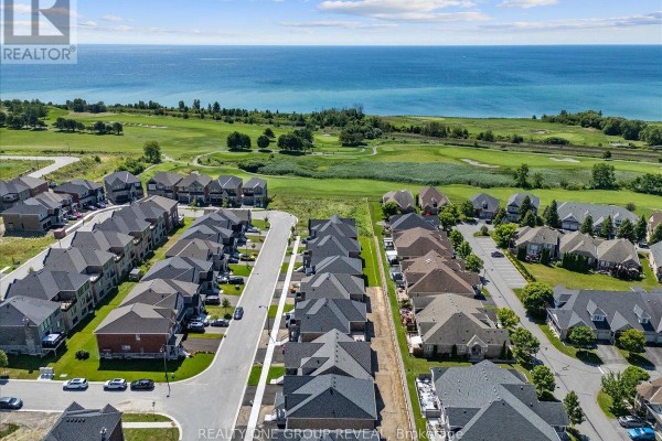 Aerial view of a suburban neighbourhood with a golf course and a large body of water in the distance. - 9 Holland Street, Port Hope