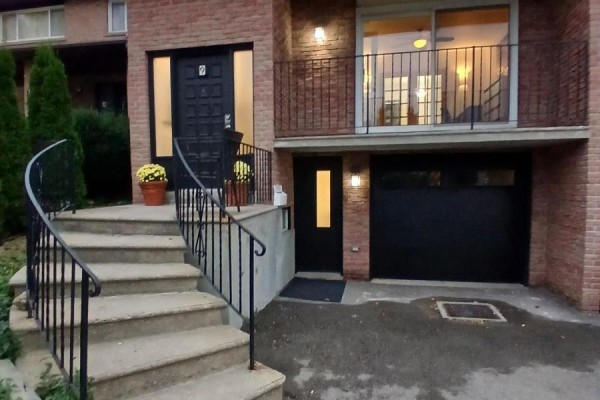 Front exterior of a brick house with stairs, garage, and balcony. - 9 Ivan Nelson Drive, Toronto