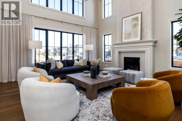 Living room with high ceilings, large windows, a fireplace, and modern furniture. - 9 Legacy Vista Rise Se, Calgary