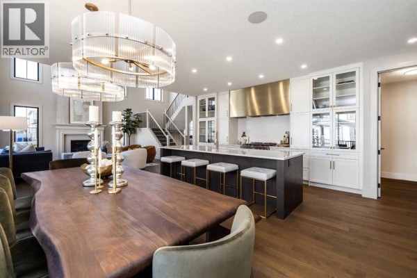 Open-concept dining area and kitchen with a live-edge wood table and large island. - 9 Legacy Vista Rise Se, Calgary