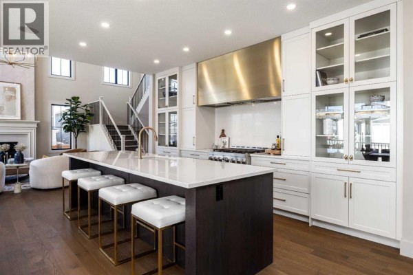 Kitchen with white cabinetry, stainless steel appliances, and a dark wood island. - 9 Legacy Vista Rise Se, Calgary
