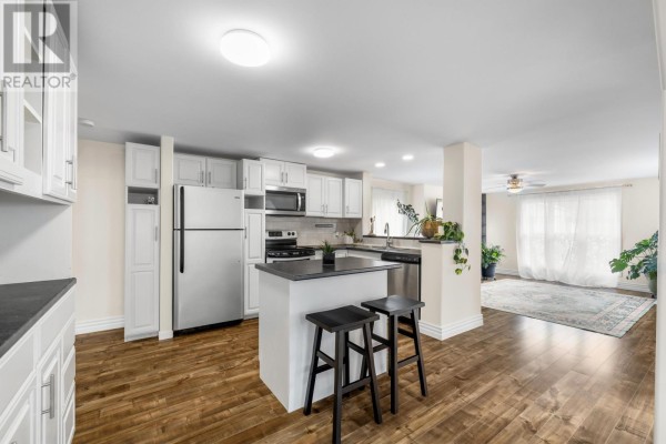 Dining area with round table, yellow chairs, and plants, featuring air conditioning unit - 9 Linkletter Estates, Summerside