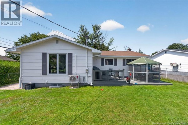Back exterior of the bungalow with a wooden deck and screened gazebo. - 9 Magellan Drive, Moncton