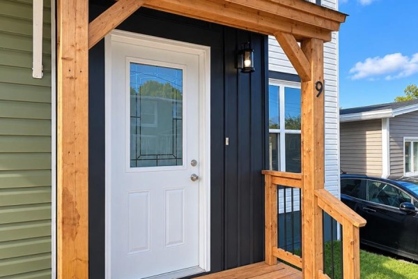 Close-up of the front door entrance with a wooden porch and black siding. - 9 Malta Street, St  John S