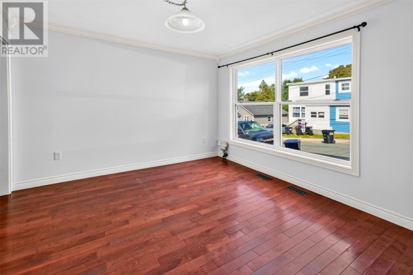 Empty room with dark wood floors and a large window facing the street. - 9 Malta Street, St  John S