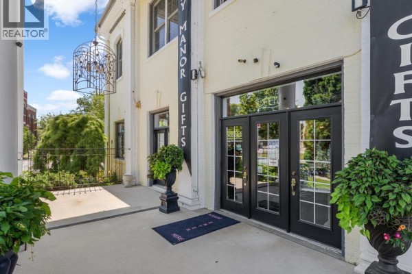 Entrance to a commercial building with double glass doors, planters, and a welcome mat. - 9 Park Street, Chatham