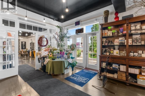 Interior view of a commercial space with retail displays, floral arrangements, and hair salon area. - 9 Park Street, Chatham