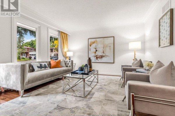 Living room with a grey tufted sofa, armchairs, a glass coffee table, and large windows. - 9 Tigerlily Court, Toronto
