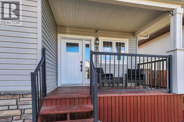 Close-up of the front door and porch steps with dark railings and seating. - 9 Valley Crescent, Blackfalds