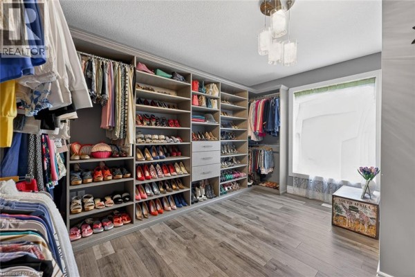 Spacious walk-in closet with floor-to-ceiling shelving and drawers, displaying organized shoes, clothes, and accessories. - 9 West Street N, Springford
