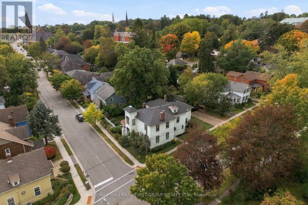 Aerial view of a cream-colored house on a tree-lined street with other residences. - 90 Brown Street, Port Hope