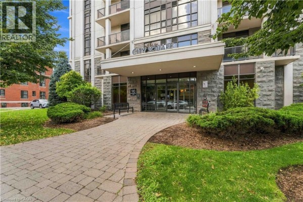 Stone-faced entrance to the City Square apartment building with a paved walkway. - 90 Charlton Avenue W Unit# 203, Hamilton