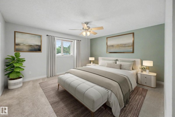 Primary bedroom with a king-size bed, green accent wall, and a ceiling fan. - 90 Dufferin St, St  Albert