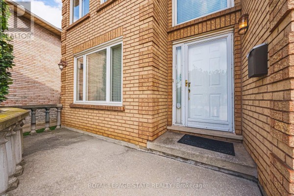 Close-up of the white front door and entryway of a brick house with a concrete walkway. - 90 Fairington Crescent, Hamilton