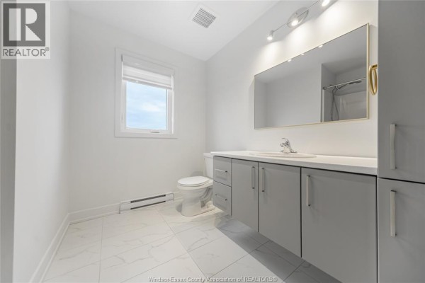 Open concept living area with kitchen island, white countertops, and dining area with wood floors. - 90 Rutile Street, Clarence Rockland