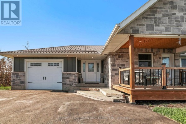 Close-up of the house entrance, garage, porch, and stone detailing. - 90 Seymour Street W, Centre Hastings