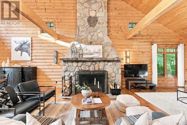 Living room with stone fireplace and exposed beams - 90 Swallowdale Road Huntsville