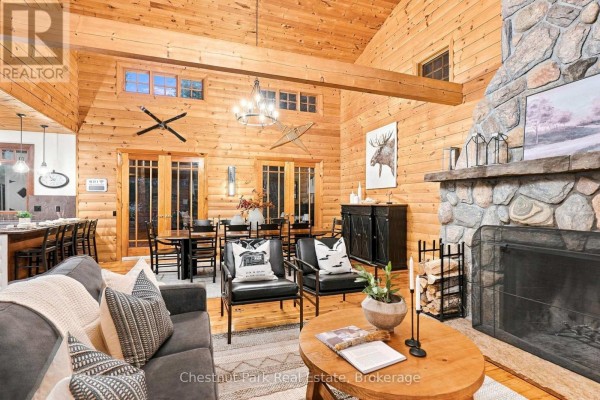 Living room with wood paneling, stone fireplace, and vaulted ceiling - 90 Swallowdale Road Huntsville