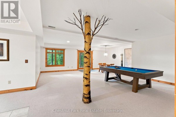 Pool table and dining set in finished basement with unique tree column - 90 Swallowdale Road Huntsville