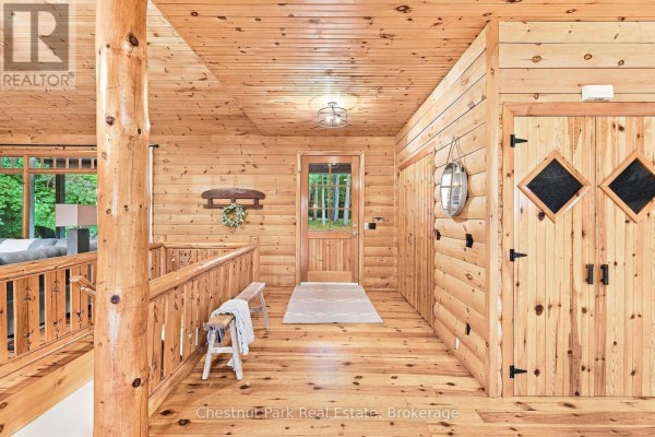 Hallway with wood paneling, bench, and double doors with diamond panes - 90 Swallowdale Road Huntsville